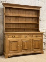 A polished pine dresser, fitted with a three height plate rack, above three drawers and three