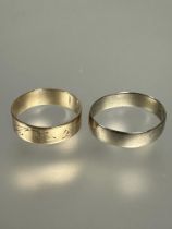 A 9ct gold engraved wedding band with scrolling leaf design S and a 9ct gold wedding band U/V 5.