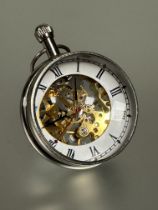 A modern chrome plated desk bubble clock with white enamel dial and roman numerals, visible skeleton