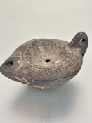 A circa 2nd Century AD Roman terracotta pottery crusie lamp  with moulded concave center within a