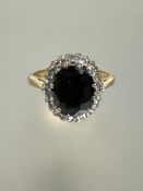 An 18ct gold sapphire and diamond cluster ring, the oval sapphire approximately 1.5ct in claw