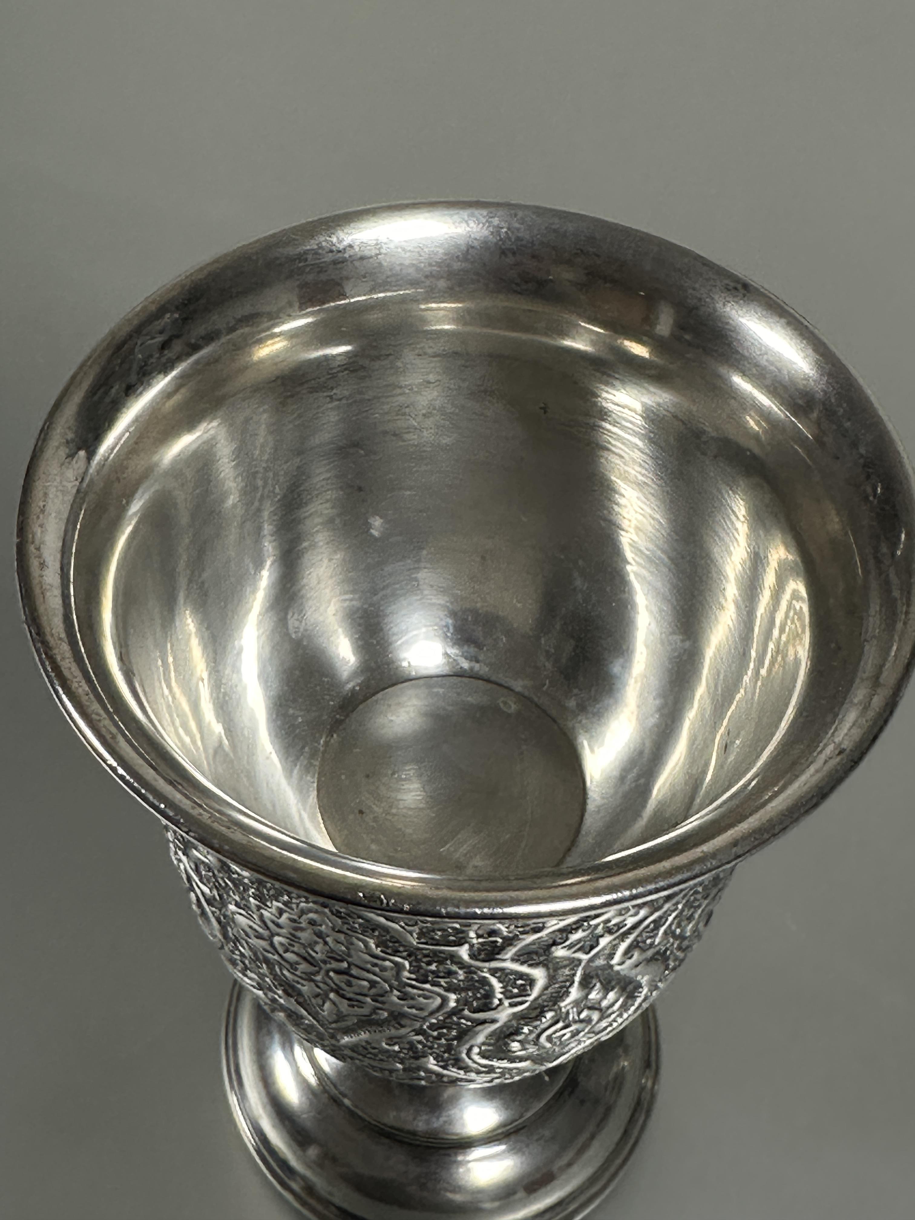 A Eastern white metal chased ceremonial chalice with repeating lotus leaf and flower design on - Image 2 of 3