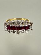 An 18ct gold ruby and diamond cluster ring set five cushion cut rubies, approximately 1ct in