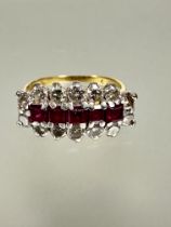 An 18ct gold ruby and diamond cluster ring set five cushion cut rubies, approximately 1ct in