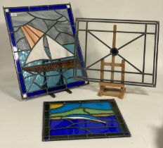 A group of three lead glazed and stained glass panels. largest 59cm x 58cm.