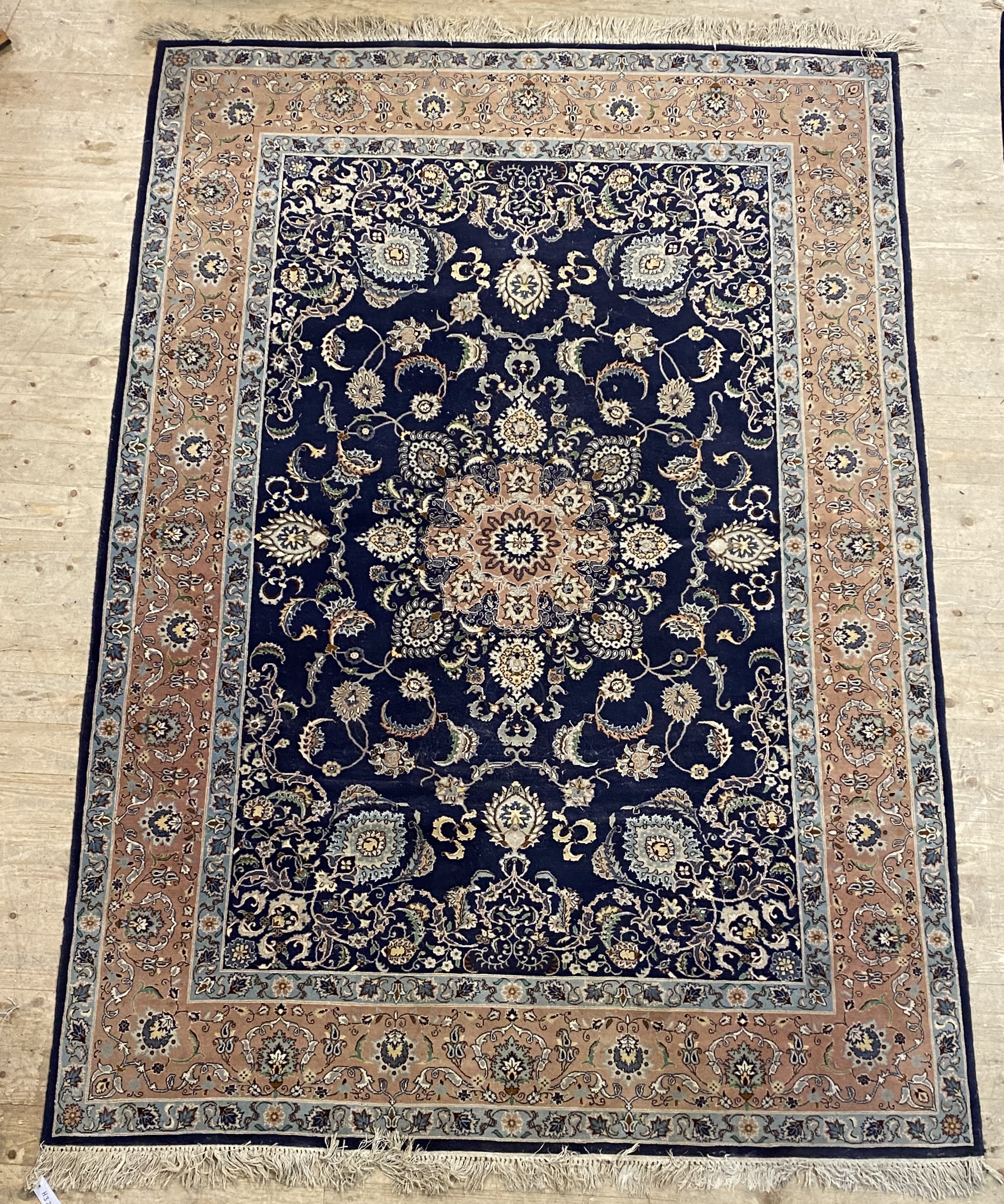 A Persian style rug, the dark blue field with centre medallion and lotus head motifs and bordered