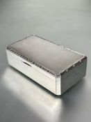 A Birmingham silver rectangular paneled corner cigarette box the top with engine turned design