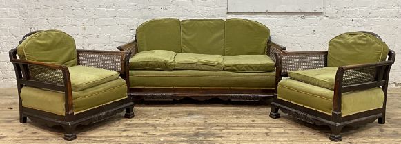 A 1920's walnut three piece bergere suite with single cane panel backs and sides, comprising a three