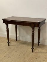 A Victorian mahogany tea table, the fold over revolving top raised on turned and tapered supports.