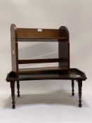 An early 20th century oak tabletop book trough with open shelf under, raised on arched panel end