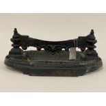 A 19th century cast iron boot scraper, the scraper mounted on two urn supports above an oval