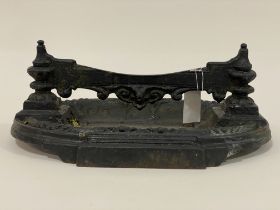A 19th century cast iron boot scraper, the scraper mounted on two urn supports above an oval