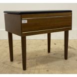 A mid century teak veneered sewing box stool, the vinyl covered top opening to a fitted interior