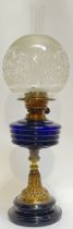 A brass and blue glass oil lamp with etched glass shade (total height- 60cm), together with a cast