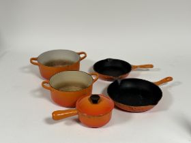 A collection of Le Creuset Flame enamelled cookware comprising, two cast iron frying pans 23 (l-