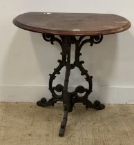 A Victorian style cast iron pub table, the demi lune mahogany top above three floral cast and