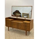 A mid century teak dressing table, the rectangular swing mirror above two long and four short