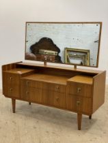 A mid century teak dressing table, the rectangular swing mirror above two long and four short