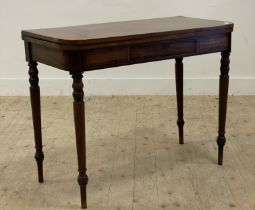 A Georgian mahogany fold over tea table, with ebonised string inlay throughout, and raised on turned