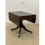 An Regency mahogany supper table, the top with brass string inlay, twin drop leaves and reeded
