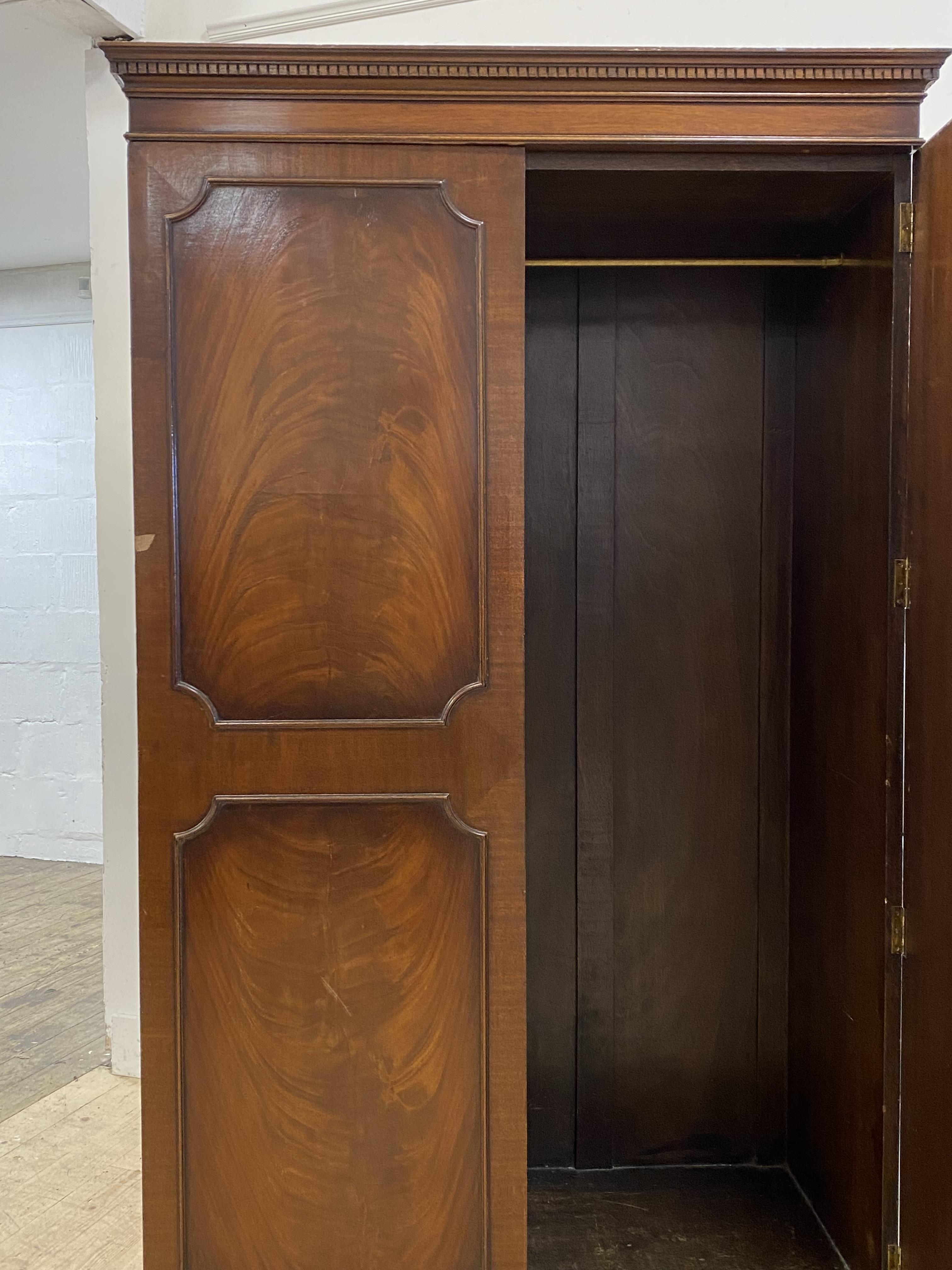 An early 20th century mahogany wardrobe, with dentil cornice over two twin panelled doors opening to - Image 2 of 2