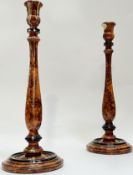 A pair of simulated walnut candlestick holders of tapered baluster form raised on circular base (