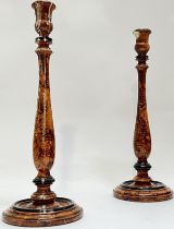 A pair of simulated walnut candlestick holders of tapered baluster form raised on circular base (
