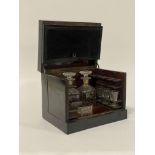 A mid19th century ebonised tantalus or drinks casket, the hinged lid enclosing a simulated