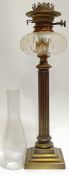 A cast lacquered brass oil lamp modelled as a fluted column with glass chimney (height excl.