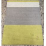 A contemporary wool rug of lineal design 230cm x 164cm.