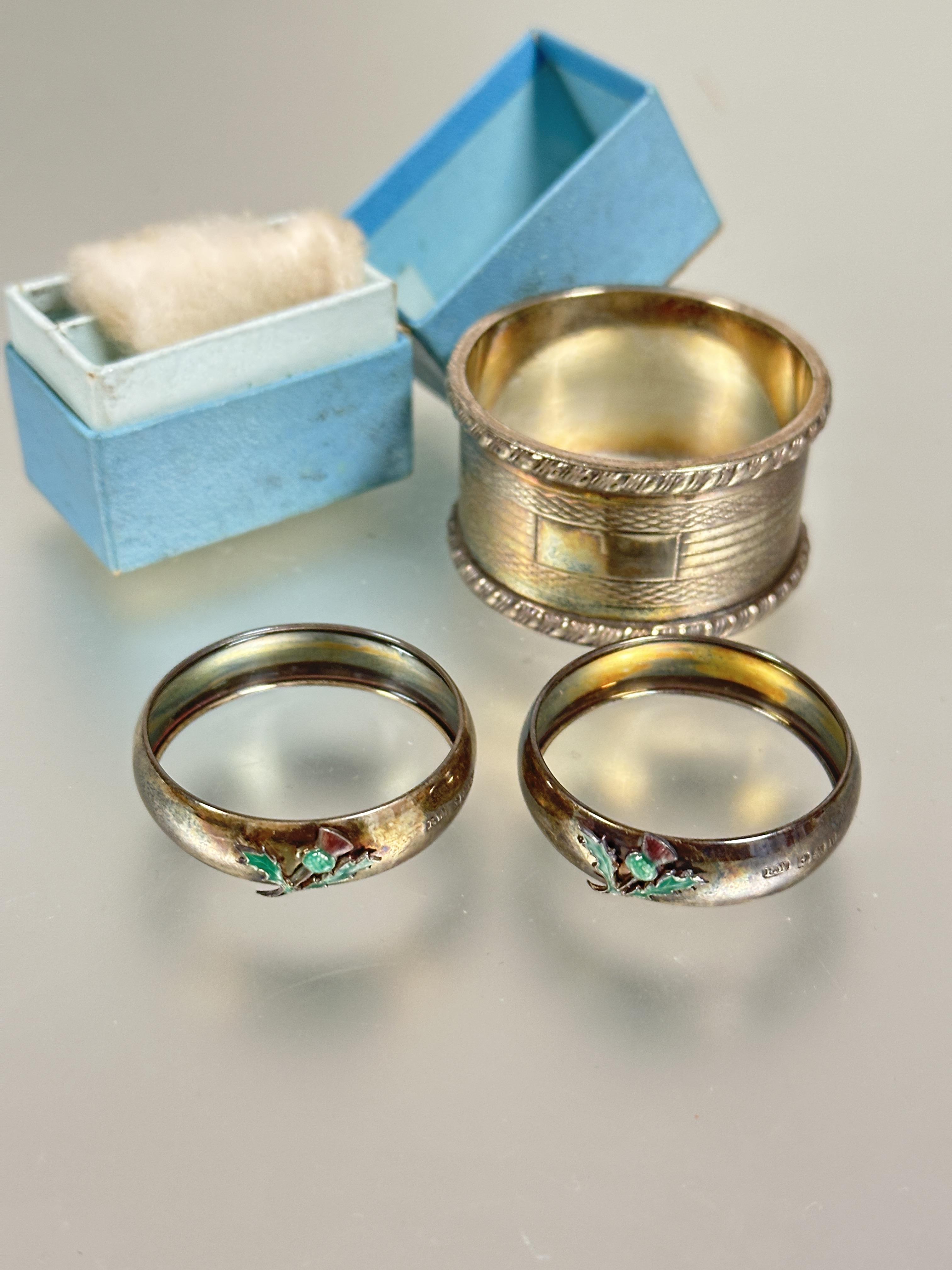 A pair of Edwardian Birmingham silver circular napkin rings mounted with enamel Scottish thistles no