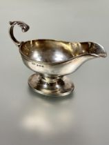 A Birmingham silver sauce boat with cast C scroll handle raised on fluted oval base Birmingham
