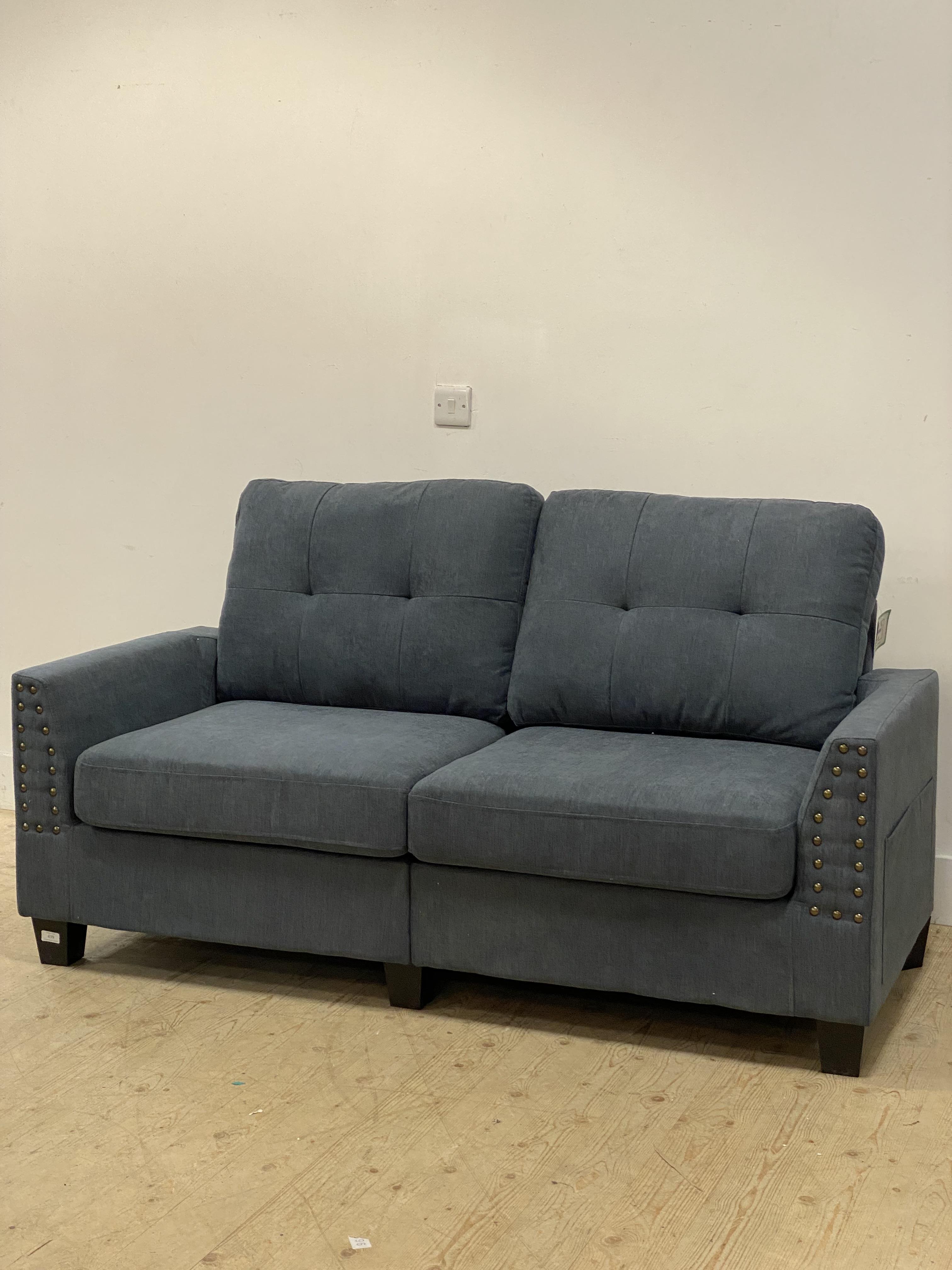 A modern two seat sofa upholstered in steel blue fabric and raised on tapered block supports. H90cm,