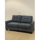 A modern two seat sofa upholstered in steel blue fabric and raised on tapered block supports. H90cm,