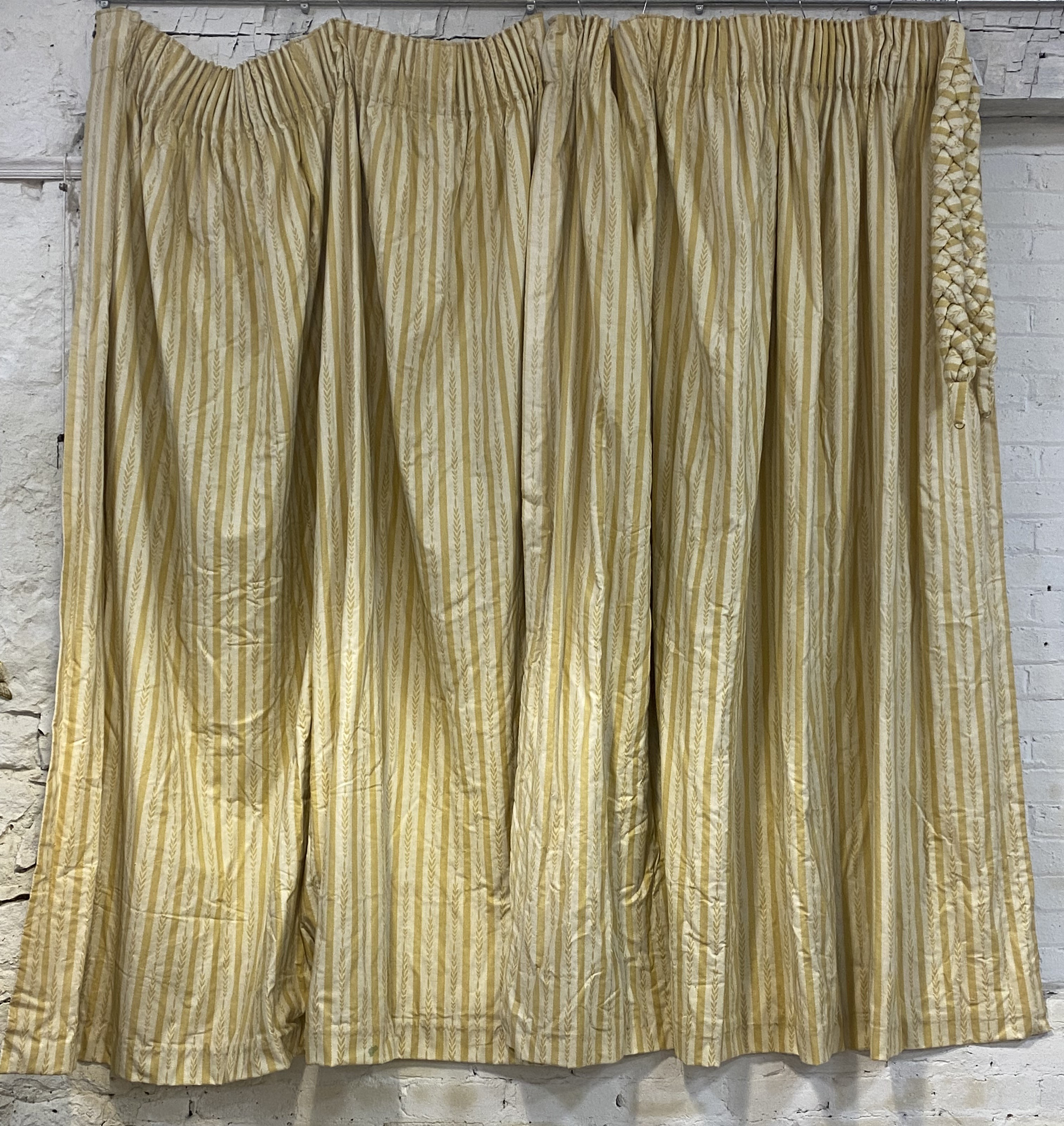 A pair of lined and thermal lined cotton pleated curtains, cream ground decorated with repeating