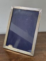 A 1920s large silver rectangular photograph frame with engine turned decoration and scrolling leaf