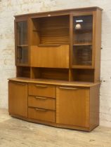 A mid century teak two part high board, the illuminated top section fitted with two glazed doors,
