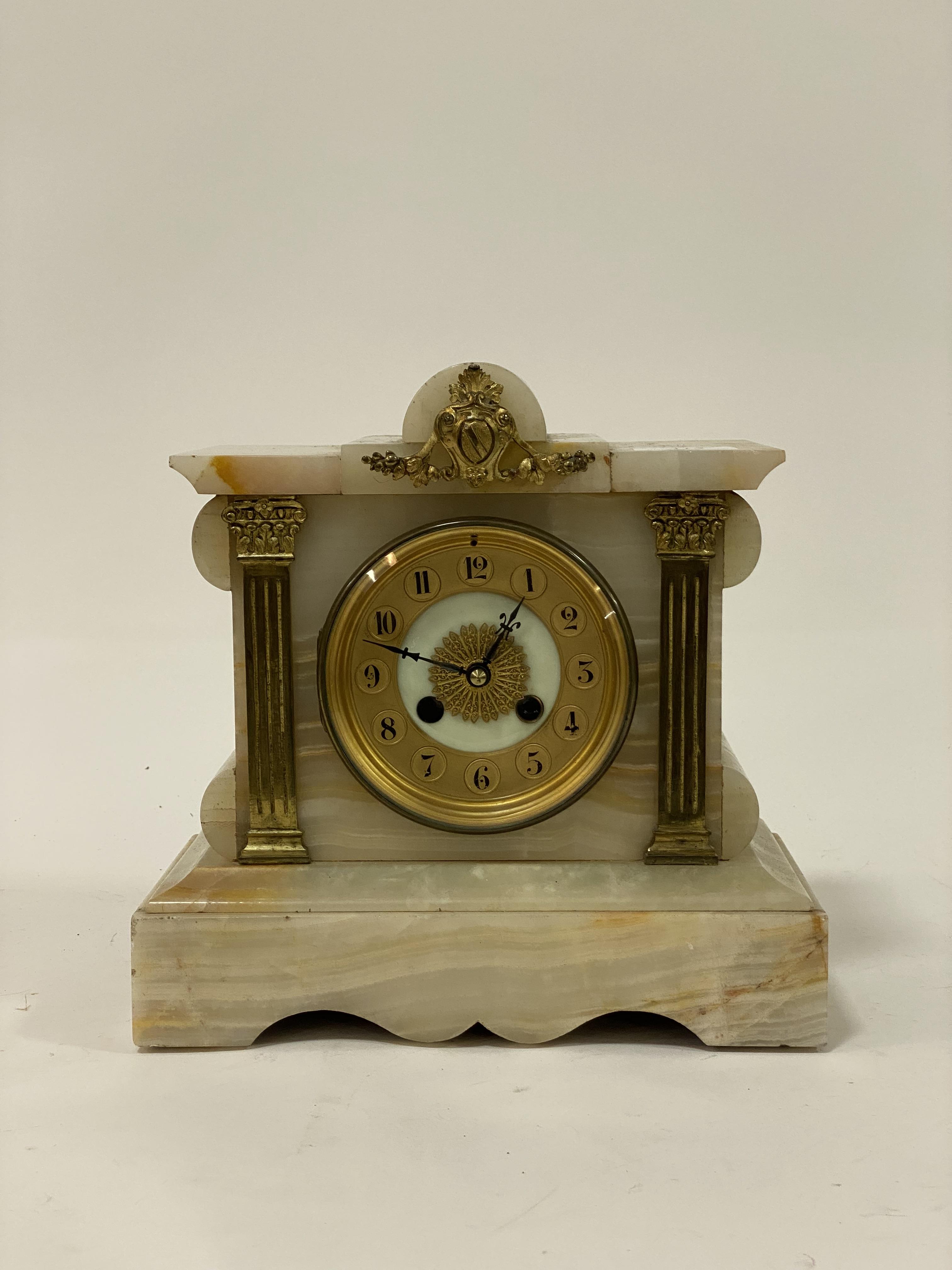 An early 20th century French onyx mantel clock, the architectural case with gilt metal mounts
