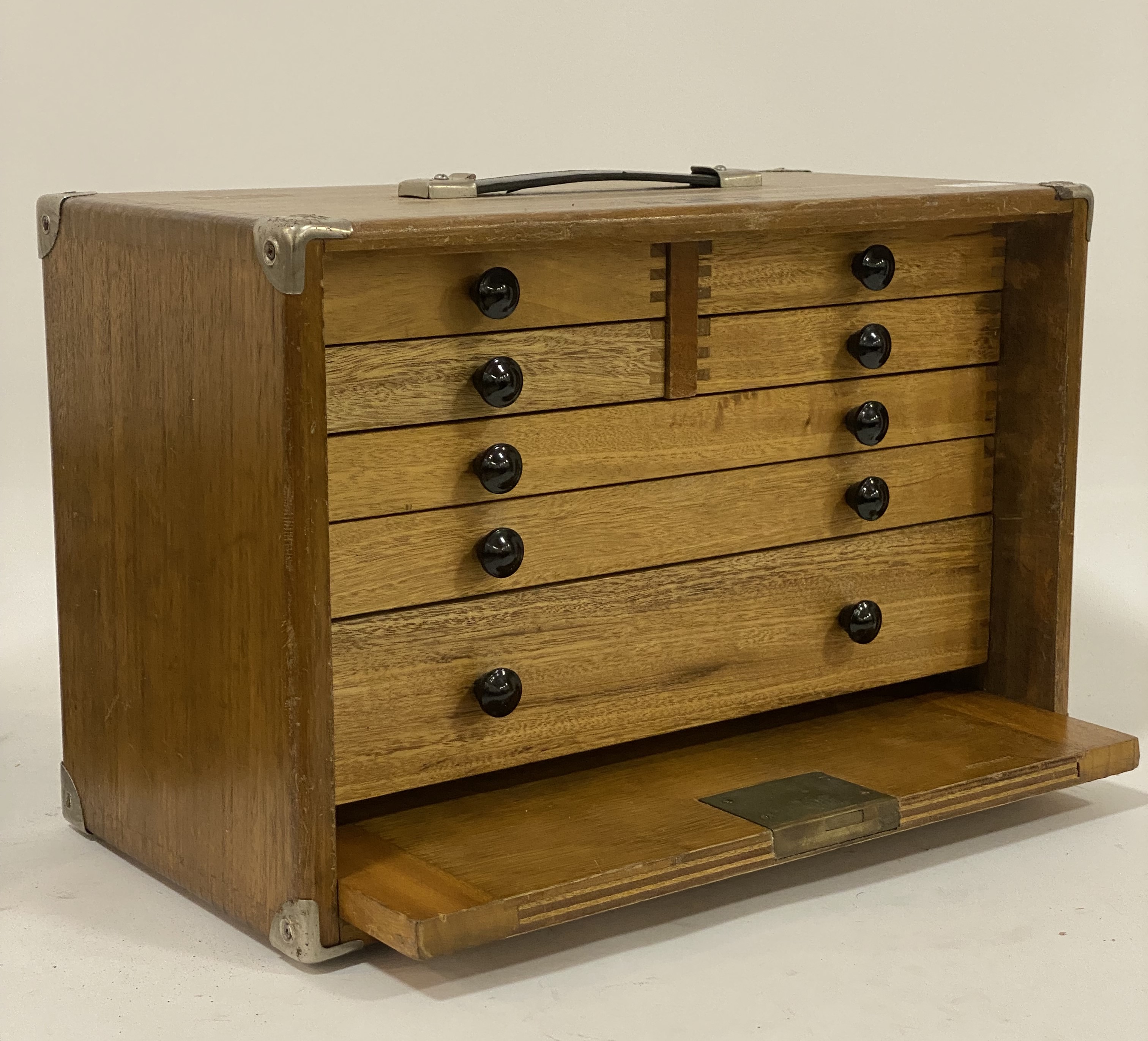 A vintage collectors cabinet, the hardwood case with metal bound corners and carry handle above a