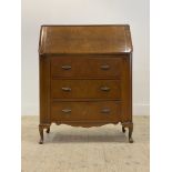 A 1930's walnut veneered bureau. the fall front opening to a fitted interior, above three drawers,