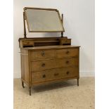 An Edwardian oak dressing chest, with geometric bevel glazed vanity mirror swivelling between two