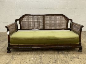 A 1920's walnut bergere sofa, with undulating back rail and cane panelled back and sides, raised