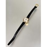 A ladys 9ct gold Tudor manual wind wrist watch with silvered dial and roman numerals with seconds