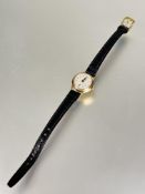 A ladys 9ct gold Tudor manual wind wrist watch with silvered dial and roman numerals with seconds