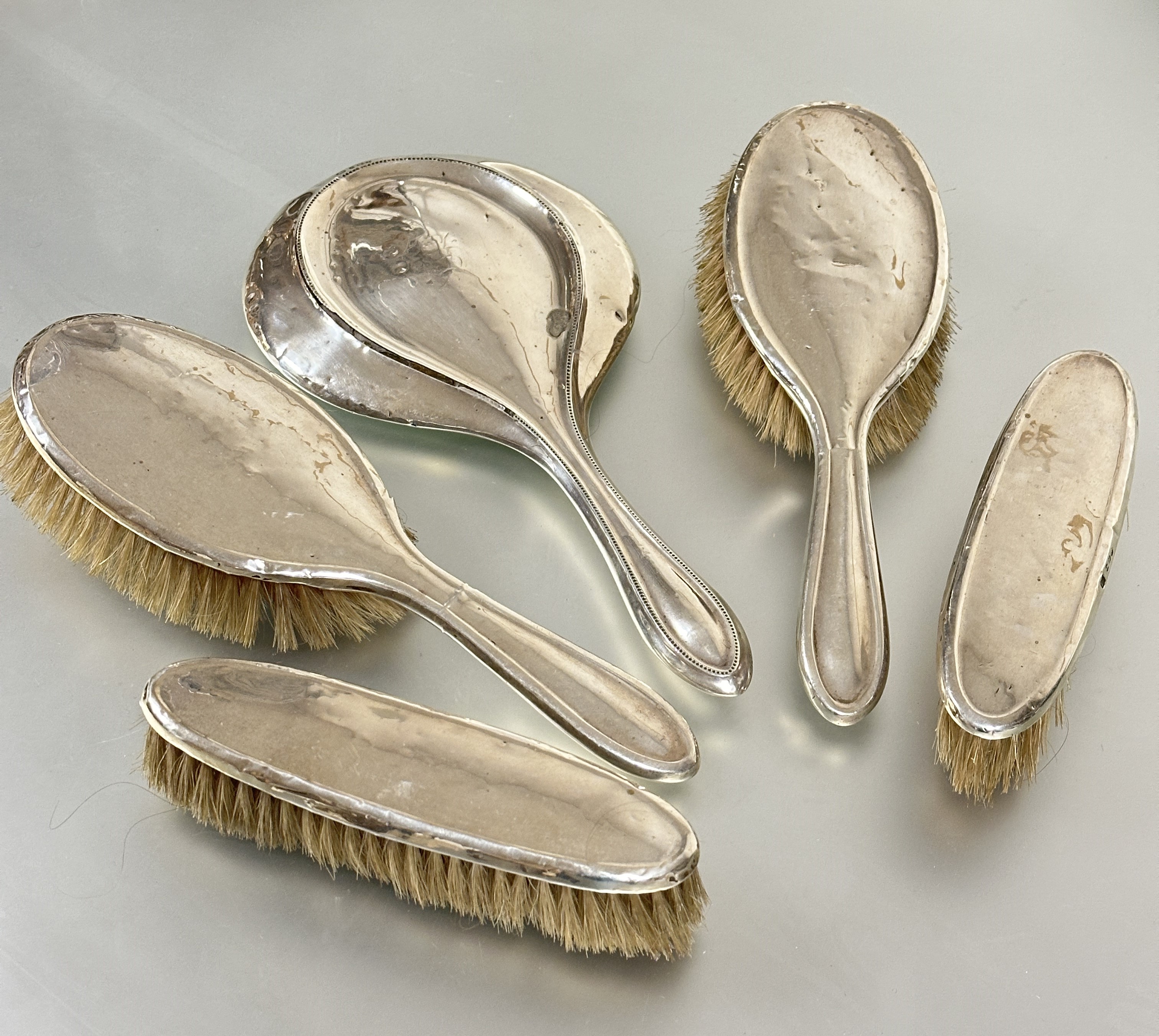 A Birmingham silver assembled dressing table set comprising a pair of oval hair brushes L x 24cm,