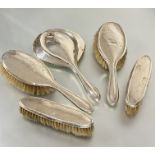 A Birmingham silver assembled dressing table set comprising a pair of oval hair brushes L x 24cm,