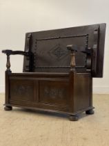 An early to mid 20th century oak monks bench, the fold over top / back rest carved with lozenge