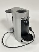 A silvered cased Nespresso pod coffee maker shows little to no signs of use with modern fitted