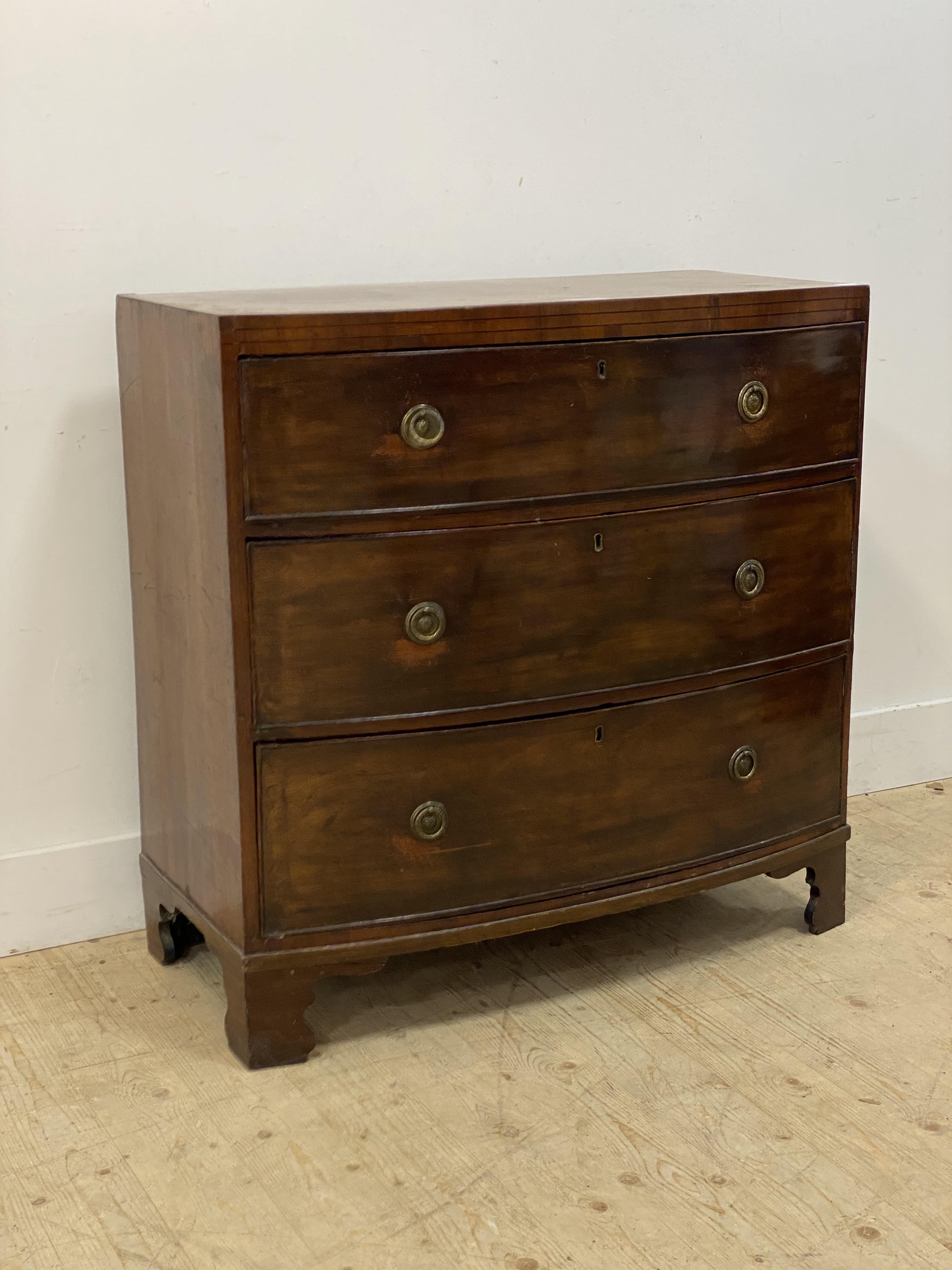 A Regency mahogany bow front chest, fitted with three graduated drawers and raised on bracket