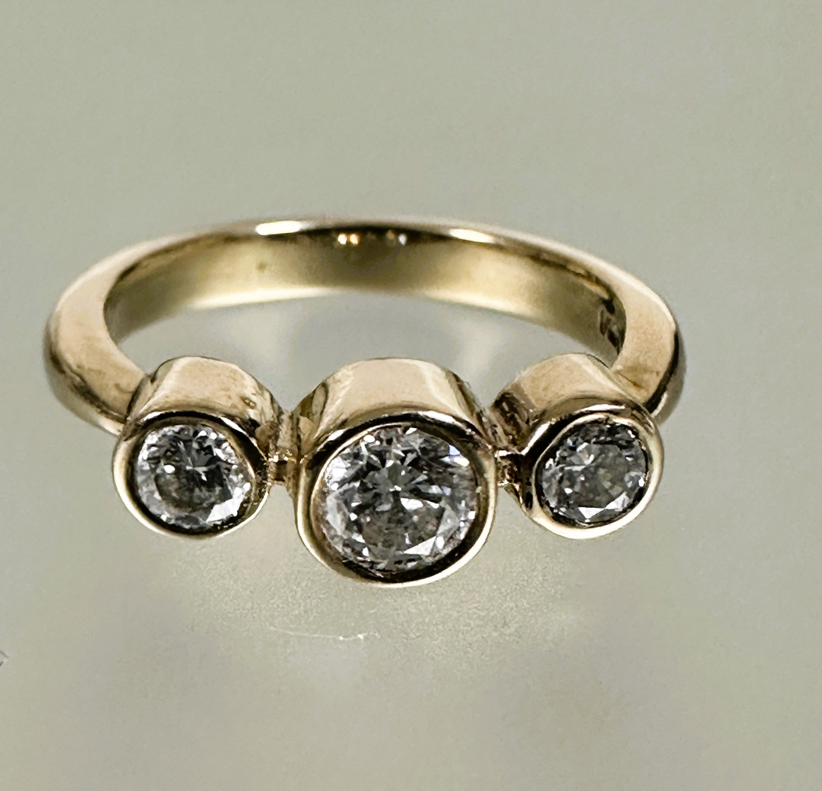 A 9ct gold diamond three stone graduated ring, the center stone approximately 0.28ct collette set